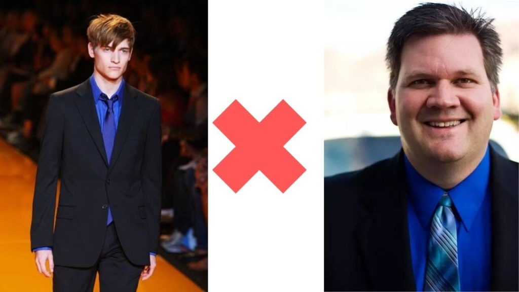 image with a red cross in between two men wearing a dark blue shirt with a black suit.